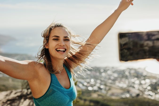 Excited woman celebrating hiking victory with a selfie