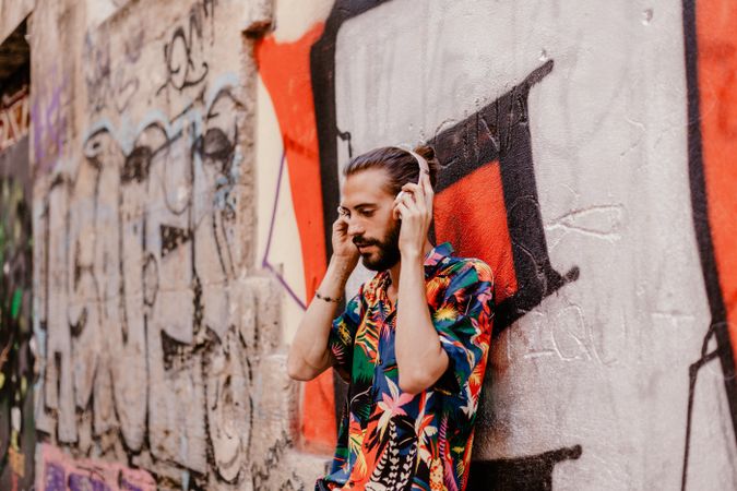 Smiling man listening to music and using smartphone
