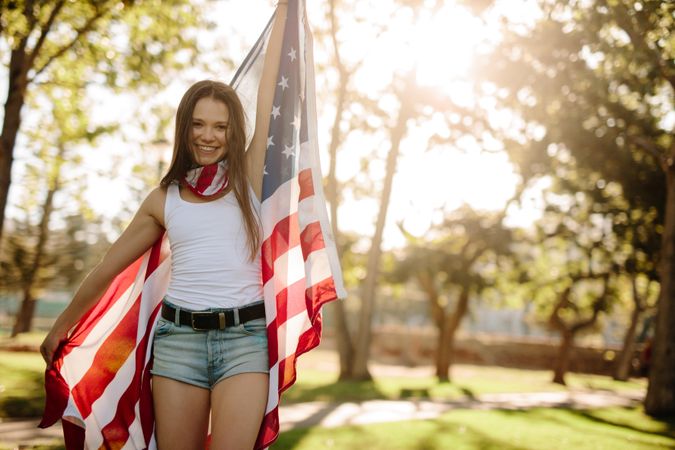 Portrait of a beautiful woman in the park with American flag