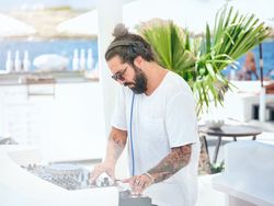 DJ working on controller on resort hotel terrace