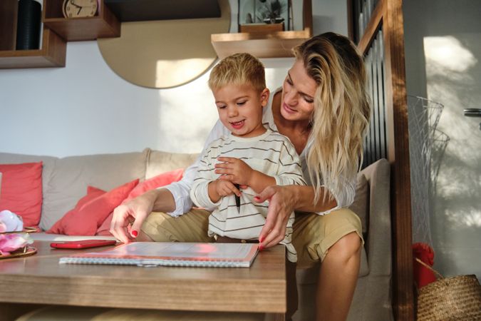Mother and son sitting on couch and looking at notepad