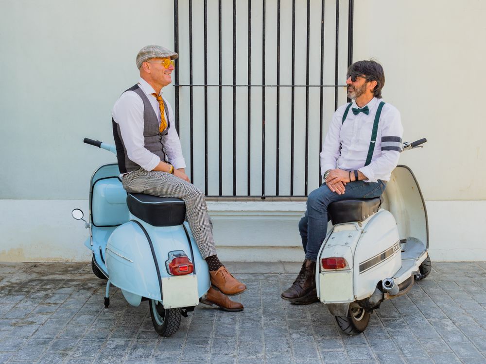 Trendy men sitting on vintage scooters