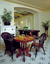 Card table with wicker chairs in airy, tiled room E4AlR5