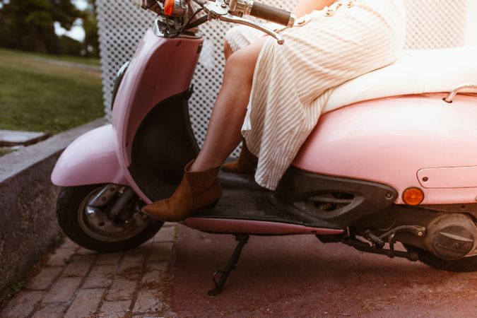 Stylish woman sitting on bike with open leg in beautiful boot