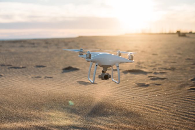 Drone flying approaching sandy beach