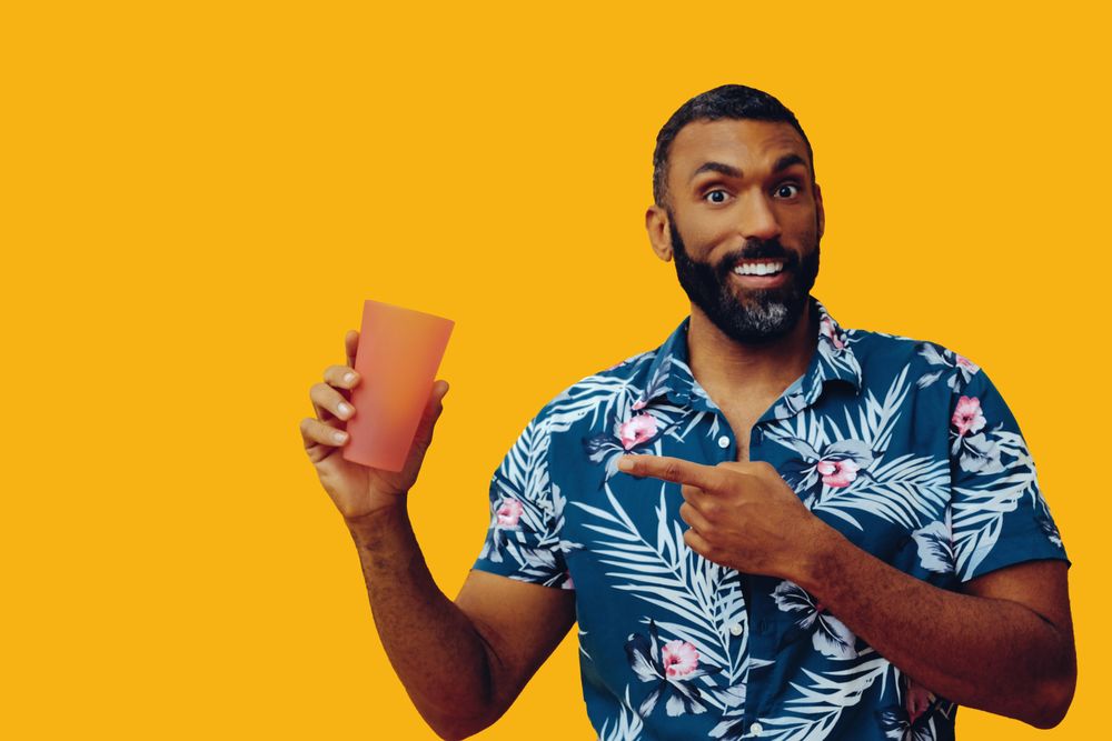 Male pointing at his refreshing drink in a orange cup with copy space