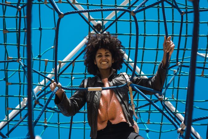 Woman with afro hair climbing by children's attractions.
