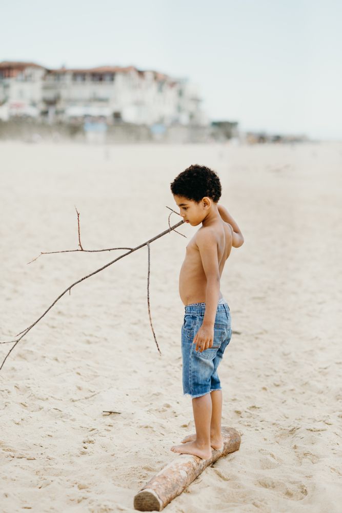 Anonymous Black kid walking on log