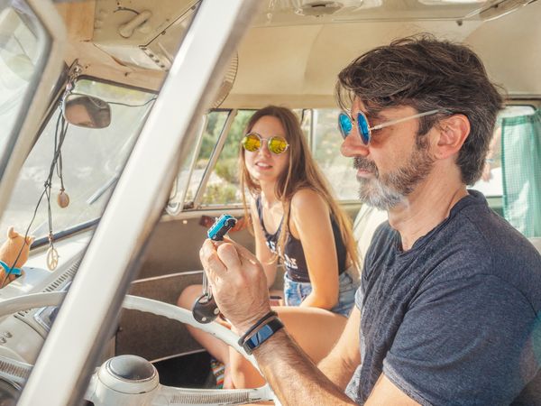 Man and woman watching and discussing blue thing in car