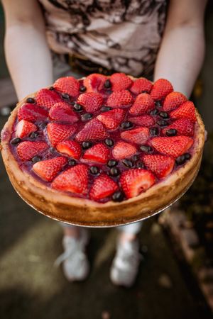 unrecognizable woman holding a delicious strawberry pie
