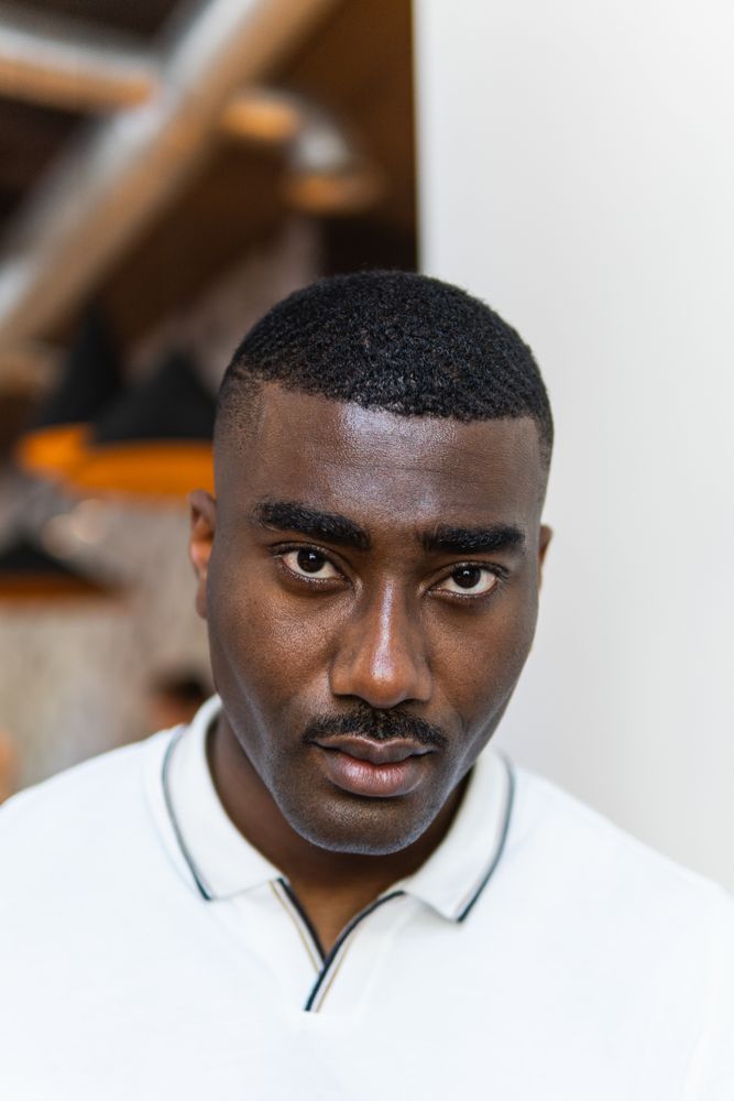 Serious Black man in eyeglasses on white background