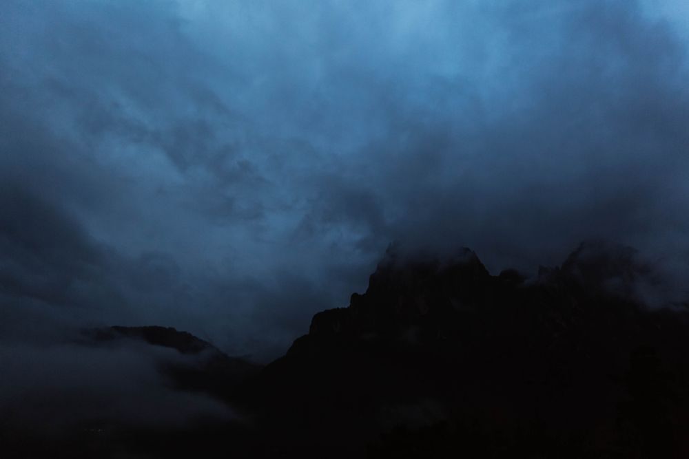 Big mountains near pine forest on cloudy weather