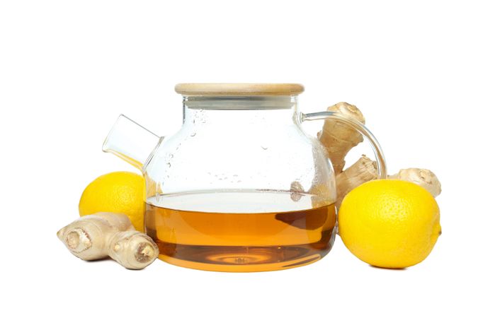 Teapot with tea, lemon and ginger, isolated on plain background