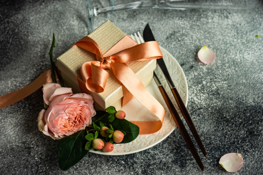 Pink flowers with gift wrapped in pink ribbon