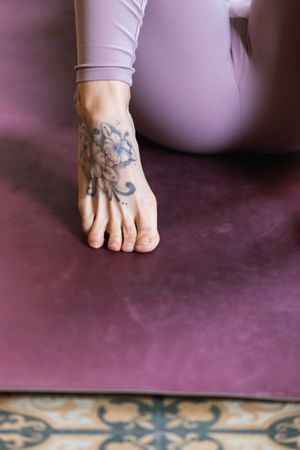 Crop foot of tattooed woman in sports clothes
