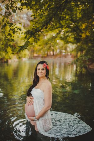 Pregnant woman standing in lake water
