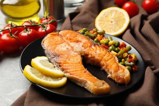 Composition with tasty grilled salmon on gray background, close up