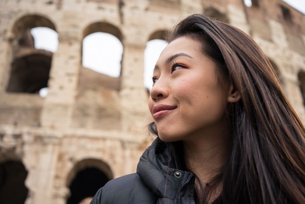 Cheerful Asian traveler outside famous landmark