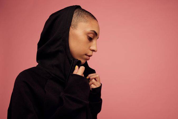 Female with shaved head on pink background