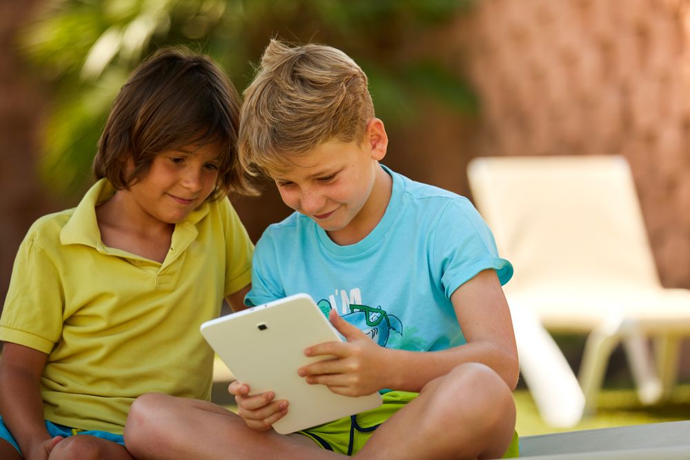 Content boys using tablet chilling in garden