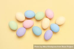 Colorful pastel eggs scattered  on yellow background bGOjBb