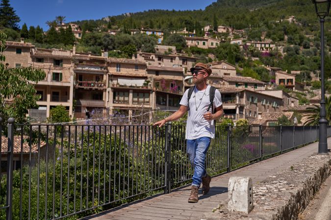 Male tourist walking on pathway and observing old town