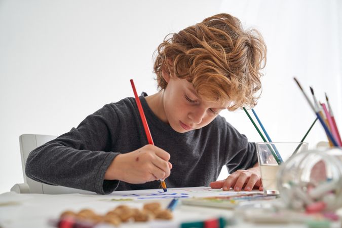 Focused boy painting on paper