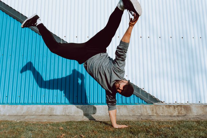 Man performing handstand near wall