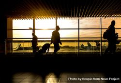 Silhouette of people walking in the airport at sunset bx6Ej5