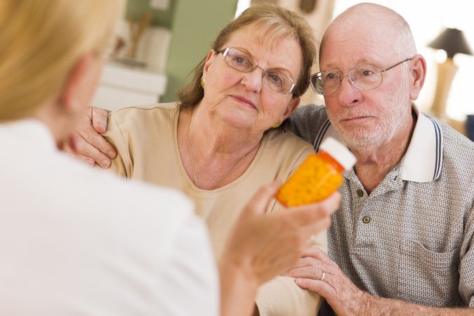 Doctor or Nurse Explaining Prescription Medicine to Older Couple