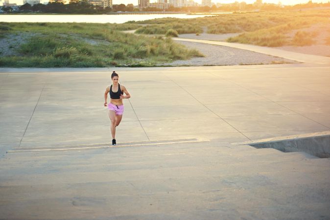 Woman in pink shorts about to jog up stairs