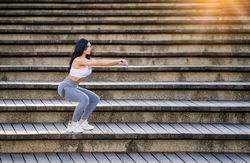 Slim woman doing yoga on stairs