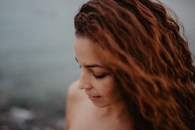Smiling red-haired woman looking down