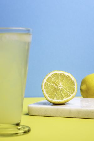 Organic lemon cut in half and glass of lemonade
