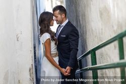 Newlyweds kissing on outdoor passageway bxBEd5