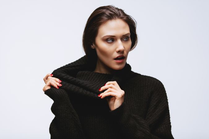 Woman pulling her turtleneck sweater
