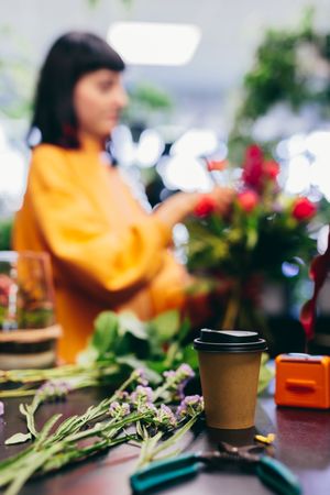 Florist's equipment and woman composing bouquet