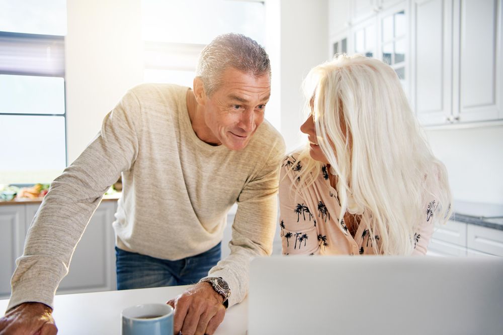 Couple in front of a laptop computer on the kitchen counter top