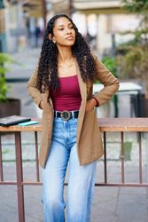 A Stylish and Young Woman is Posing Outdoors with a Trendy and Fashionable Outfit