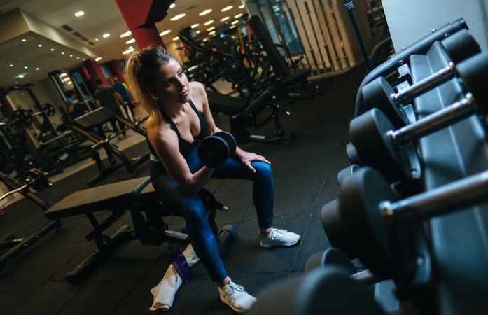 Woman lifting dumbbells on bench