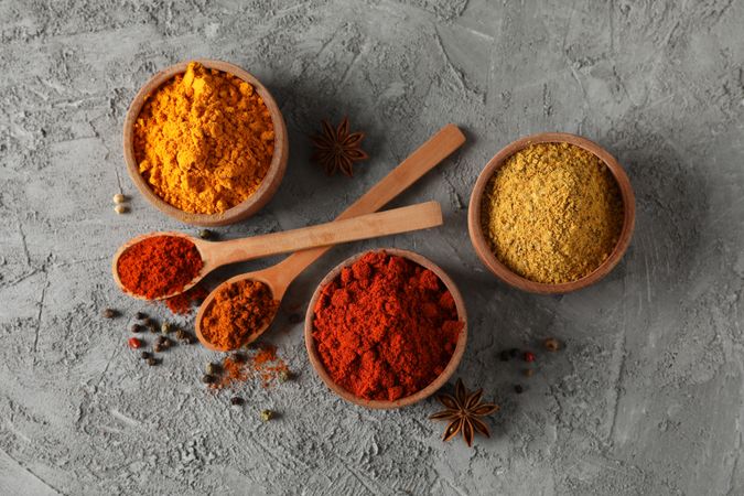 Wooden bowls with red, yellow and brown spices