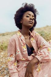 Woman in pink floral dress sitting outdoor