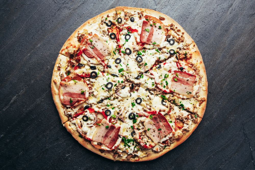 Ham pizza on stone table