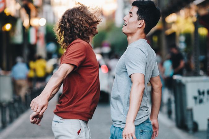 Courageous multiethnic male friends jumping and having fun on street