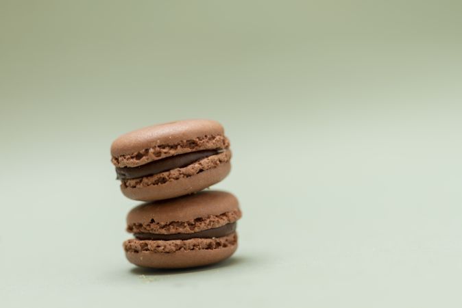 Two chocolate macaroons on a green table