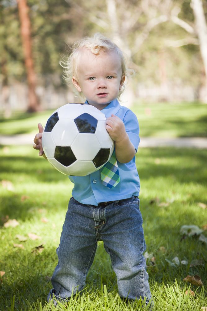 Young Cute Boy Playing with Soccer Ball in Park