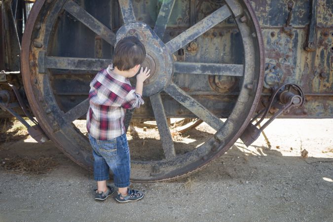 Cute Biracial Boy Having Fun Near Antique Machinery