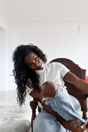 Black woman sitting in bright apartment
