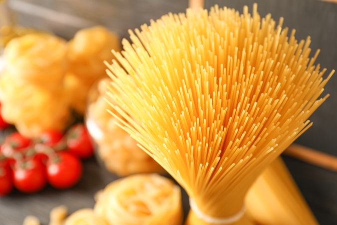 Composition with pasta cooking ingredients on wooden table, space for text and closeup