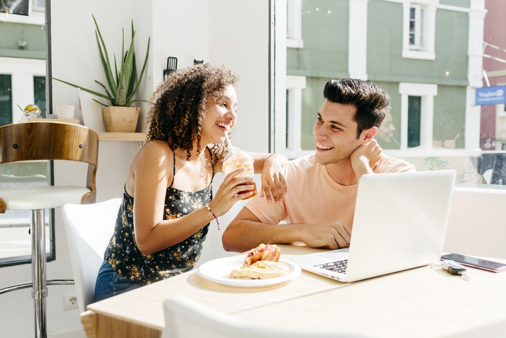 Happy diverse couple resting in restaurant
